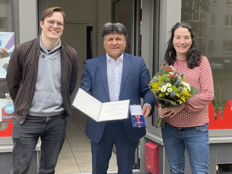 Die beiden SPD-Ortsvereinsvorsitzenden Lennart Lüdke und Julia Wagner gratulieren Mehdi Jafari Gorzini zum Bundesverdienstkreuz.