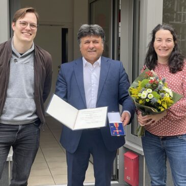 Die beiden SPD-Ortsvereinsvorsitzenden Lennart Lüdke und Julia Wagner gratulieren Mehdi Jafari Gorzini zum Bundesverdienstkreuz.